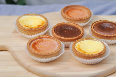 peynirli tart, çikolatalı tart ve çilek ahşap tepsi üzerinde tart