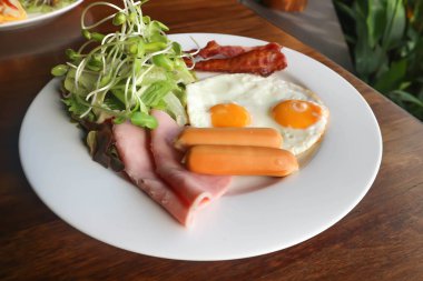 kızarmış yumurta, pastırma, sosis, jambon ve sebze tabağı