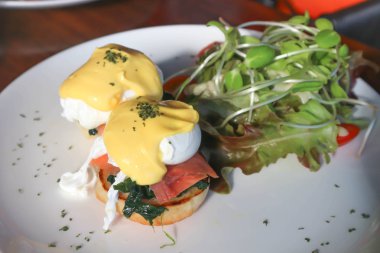 yumurta benedict ve salata yemek