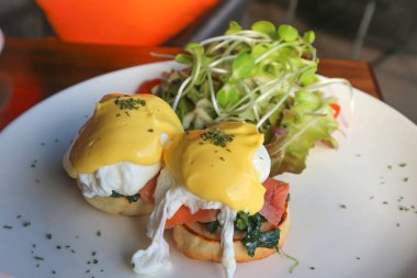 yumurta benedict ve salata yemek