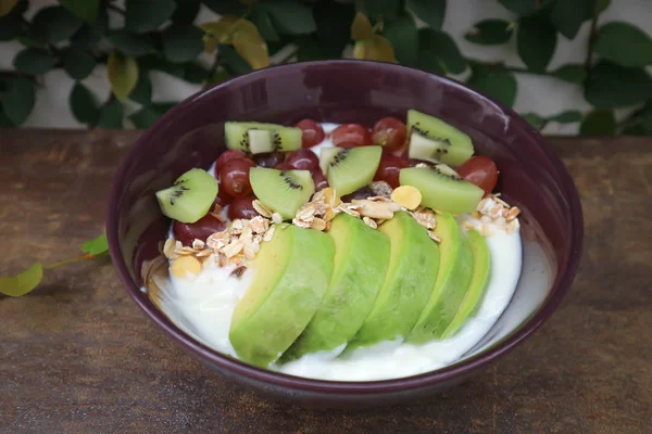 yogurt with cereal, oat, kiwi fruit and grape topping
