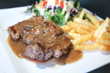 domuz eti biftek ya da sığır eti biftek ile kızarmış patates ve salata