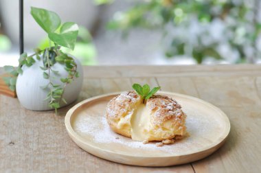 Choux kreması ya da kremalı pasta, ahşap tabakta ekin.