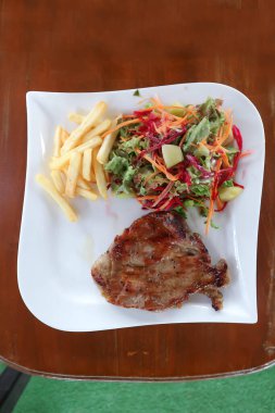 Izgara domuz eti, kızarmış domuz ya da salata ve patates kızartması ile ızgara domuz eti.