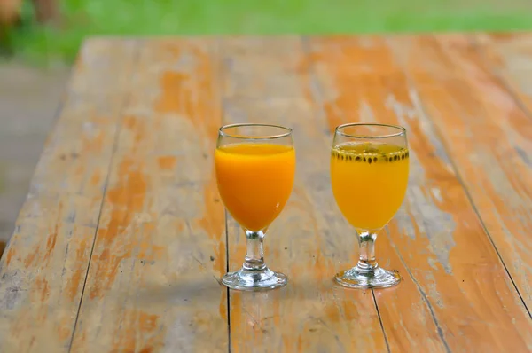 橙汁和激情果汁放在桌上 — 图库照片