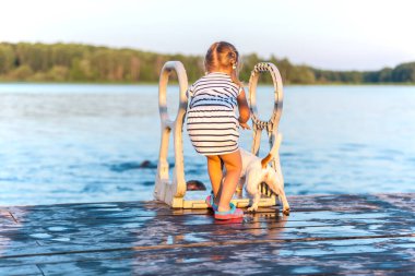 Küçük çocuklar, köpek Jack Russell Terrier ile oynuyorlar. Sıcak yaz havasına karşı.