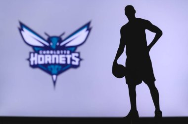 NEW YORK, ABD, 18 Haziran 2020: Amerikan profesyonel basketbol liginin Charlotte Hornets logosu. Ön planda sepetçi silueti var. Spor konsepti fotoğrafı, boşluk düzenleme.