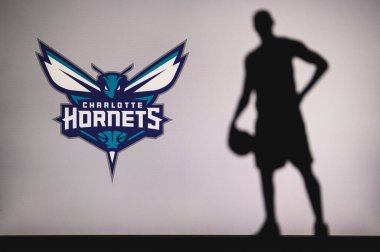 NEW YORK, ABD, 18 Haziran 2020: Amerikan profesyonel basketbol liginin Charlotte Hornets logosu. Ön planda sepetçi silueti var. Spor konsepti fotoğrafı, boşluk düzenleme.