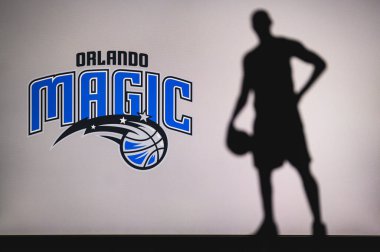NEW YORK, ABD, 18 Haziran 2020: Orlando Magic Amerikan Ligi profesyonel basketbol kulübü logosu. Ön planda sepetçi silueti var. Spor konsepti fotoğrafı, boşluk düzenleme.