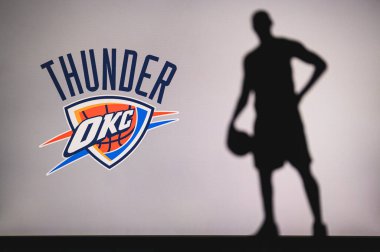 NEW YORK, ABD, 18 Haziran 2020: Oklahoma City Thunder profesyonel basketbol kulübü logosu. Ön planda sepetçi silueti var. Spor konsepti fotoğrafı, boşluk düzenleme.