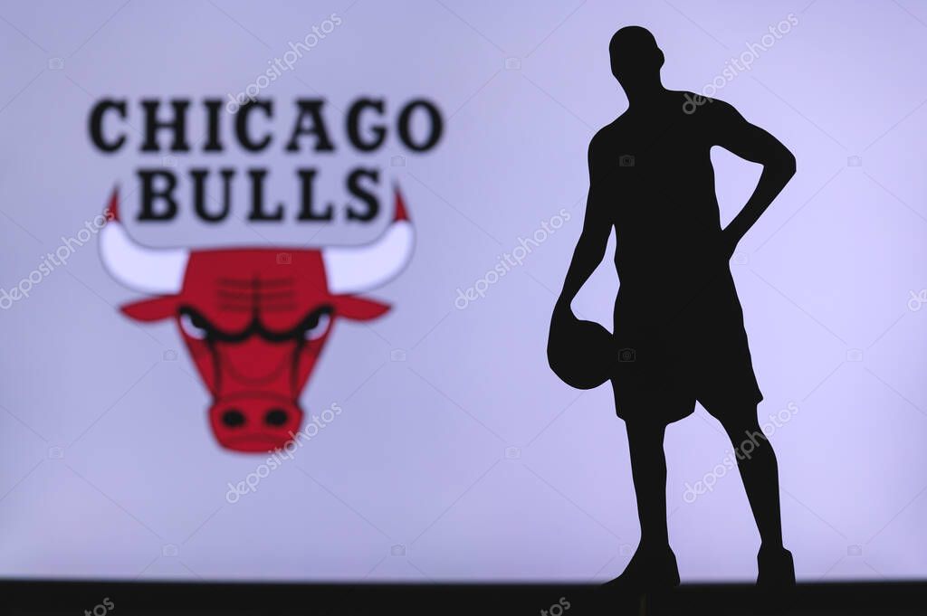 NEW YORK, USA, JUN 18, 2020: Chicago Bulls logo of professional basketball club in american league. Silhouette of basket player in foreground. Sport concept photo, edit space.