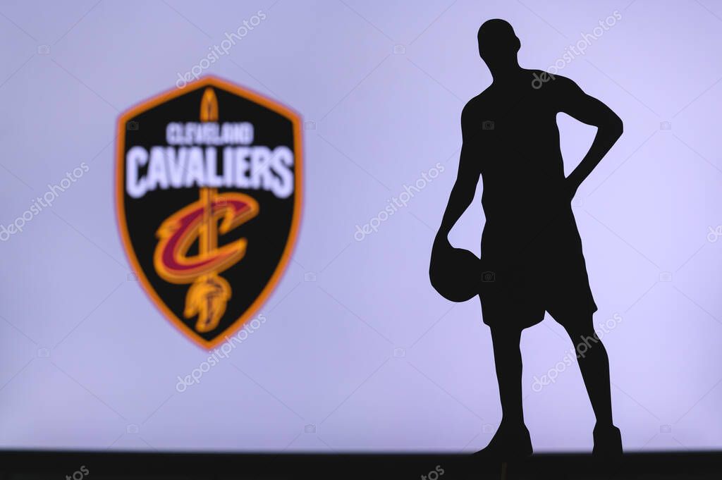 NEW YORK, USA, JUN 18, 2020: Cleveland Cavaliers logo of professional basketball club in american league. Silhouette of basket player in foreground. Sport concept photo, edit space.