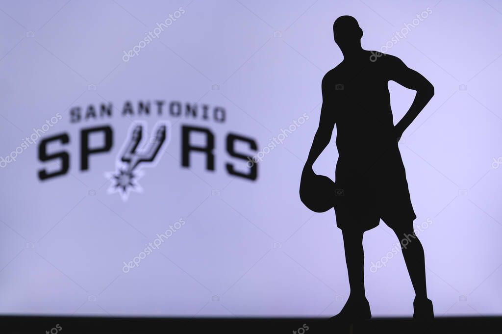 NEW YORK, USA, JUN 18, 2020: San Antonio Spurs logo of professional basketball club in american league. Silhouette of basket player in foreground. Sport concept photo, edit space.