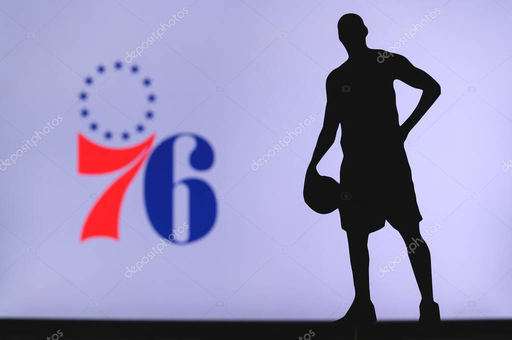 NEW YORK, USA, JUN 18, 2020: Philadelphia 76ers logo of professional basketball club in american league. Silhouette of basket player in foreground. Sport concept photo, edit space.