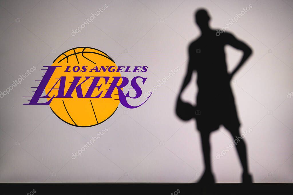 NEW YORK, USA, JUN 18, 2020: Los Angeles Lakers logo of professional basketball club in american league. Silhouette of basket player in foreground. Sport concept photo, edit space.