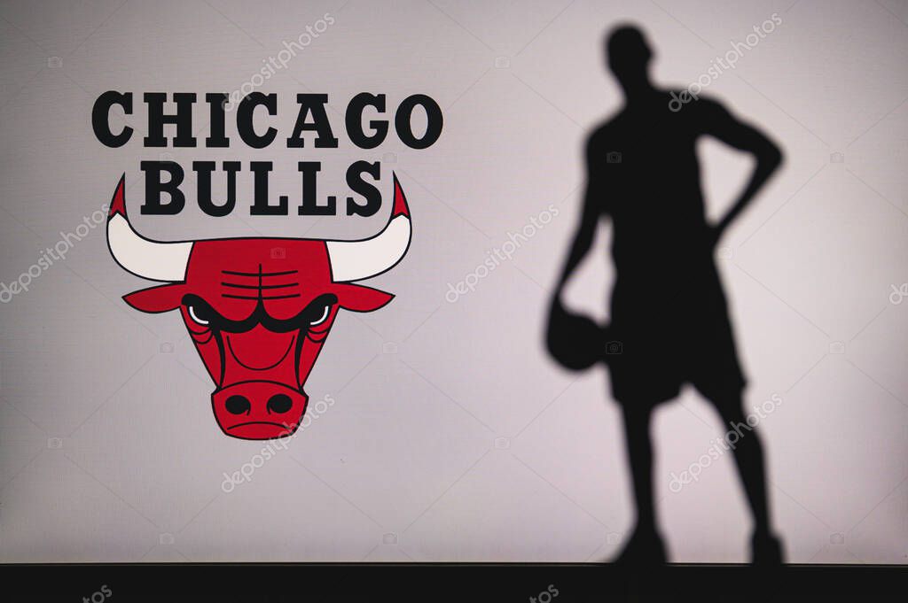 NEW YORK, USA, JUN 18, 2020: Chicago Bulls logo of professional basketball club in american league. Silhouette of basket player in foreground. Sport concept photo, edit space.