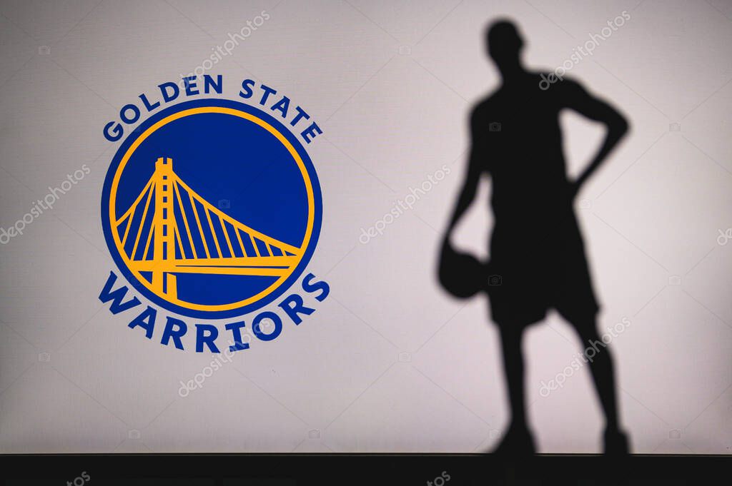 NEW YORK, USA, JUN 18, 2020: Golden State Warriors logo of professional basketball club in american league. Silhouette of basket player in foreground. Sport concept photo, edit space.