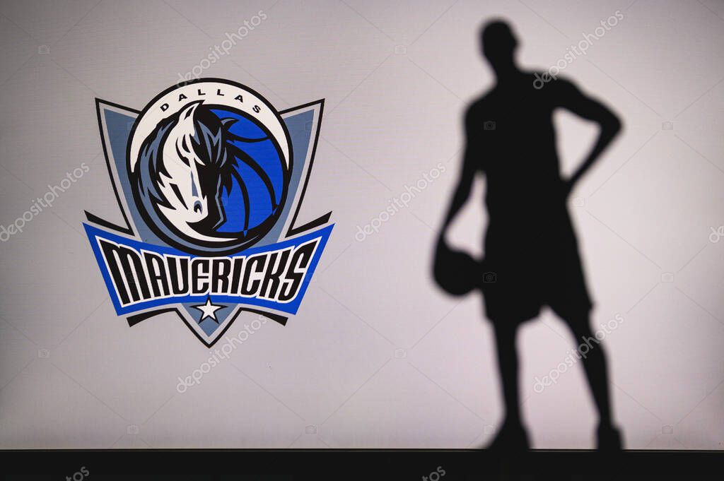 NEW YORK, USA, JUN 18, 2020: Dallas Mavericks logo of professional basketball club in american league. Silhouette of basket player in foreground. Sport concept photo, edit space.