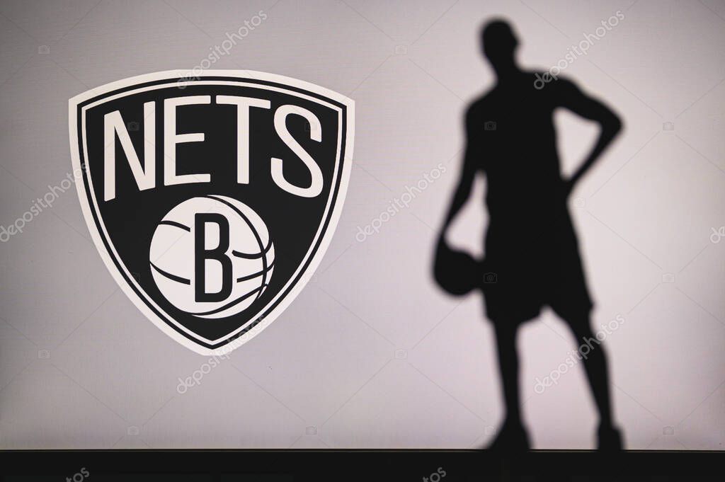 NEW YORK, USA, JUN 18, 2020: Brooklyn Nets logo of professional basketball club in american league. Silhouette of basket player in foreground. Sport concept photo, edit space.