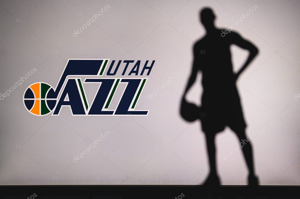 NEW YORK, USA, JUN 18, 2020: Utah Jazz logo of professional basketball club in american league. Silhouette of basket player in foreground. Sport concept photo, edit space.