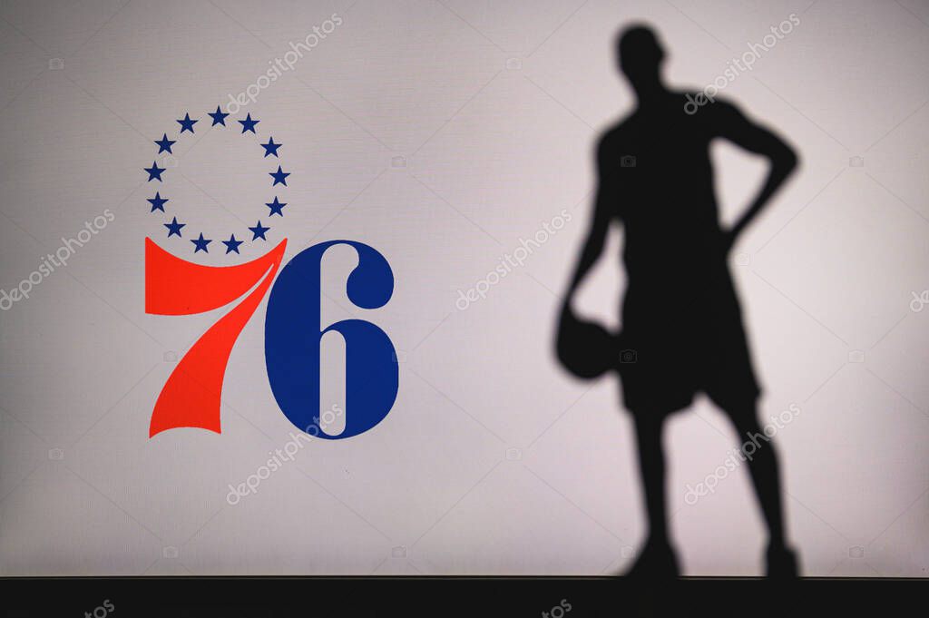 NEW YORK, USA, JUN 18, 2020: Philadelphia 76ers logo of professional basketball club in american league. Silhouette of basket player in foreground. Sport concept photo, edit space.