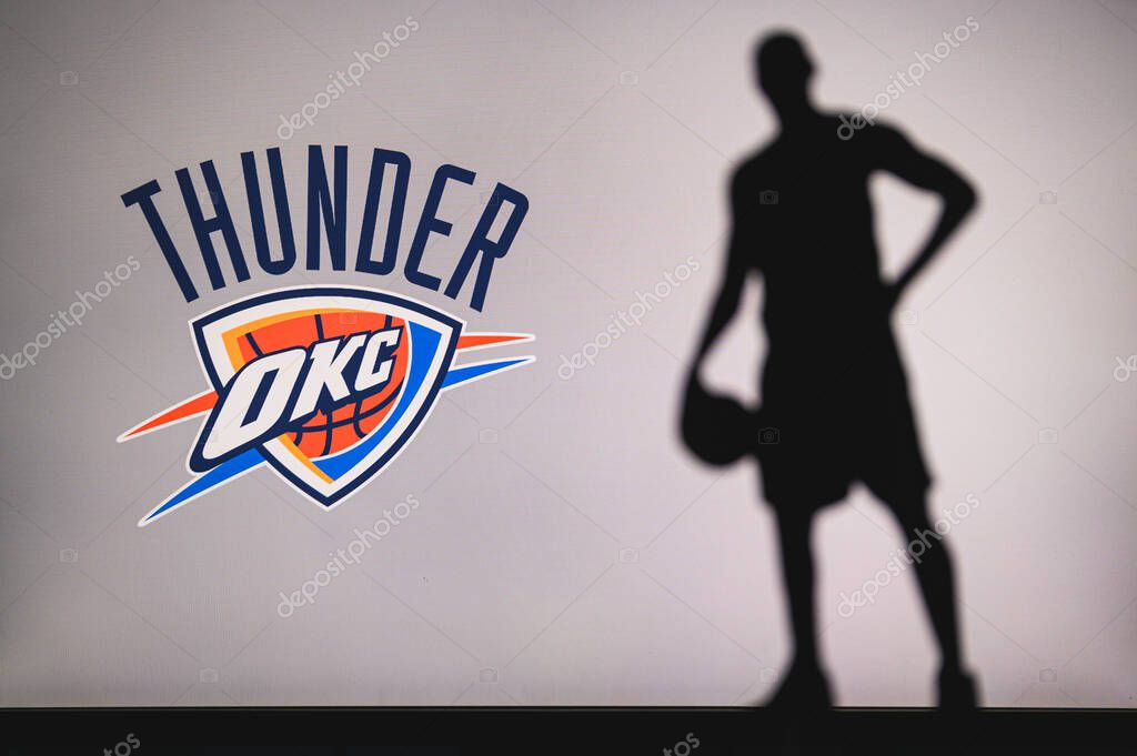 NEW YORK, USA, JUN 18, 2020: Oklahoma City Thunder logo of professional basketball club in american league. Silhouette of basket player in foreground. Sport concept photo, edit space.