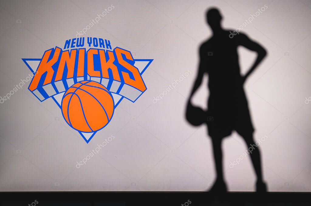 NEW YORK, USA, JUN 18, 2020: New York Knicks logo of professional basketball club in american league. Silhouette of basket player in foreground. Sport concept photo, edit space.