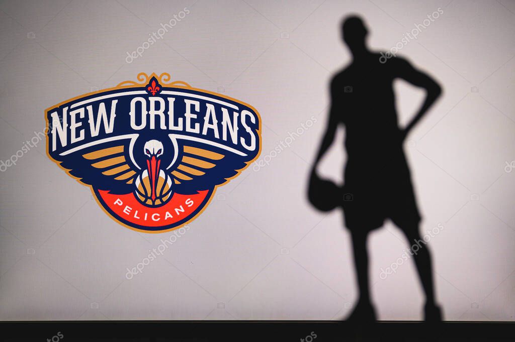 NEW YORK, USA, JUN 18, 2020: New Orleans Pelicans logo of professional basketball club in american league. Silhouette of basket player in foreground. Sport concept photo, edit space.