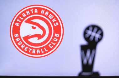 NEW YORK, ABD, 18 Haziran 2020: Atlanta Hawks Basketbol Kulübü beyaz ekranda. Ön planda NBA kupasının silueti.