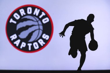 NEW YORK, ABD, 18 Haziran 2020: Toronto Raptors basketbol kulübü logosu ve genç basketbolcunun silüeti. Spor duvar kağıdı, arkaplanda beyaz düzenleme alanı.