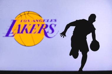 NEW YORK, ABD, 18 Haziran 2020: Los Angeles Lakers basketbol kulübü logosu ve genç basketbolcunun silüeti. Spor duvar kağıdı, arkaplanda beyaz düzenleme alanı.
