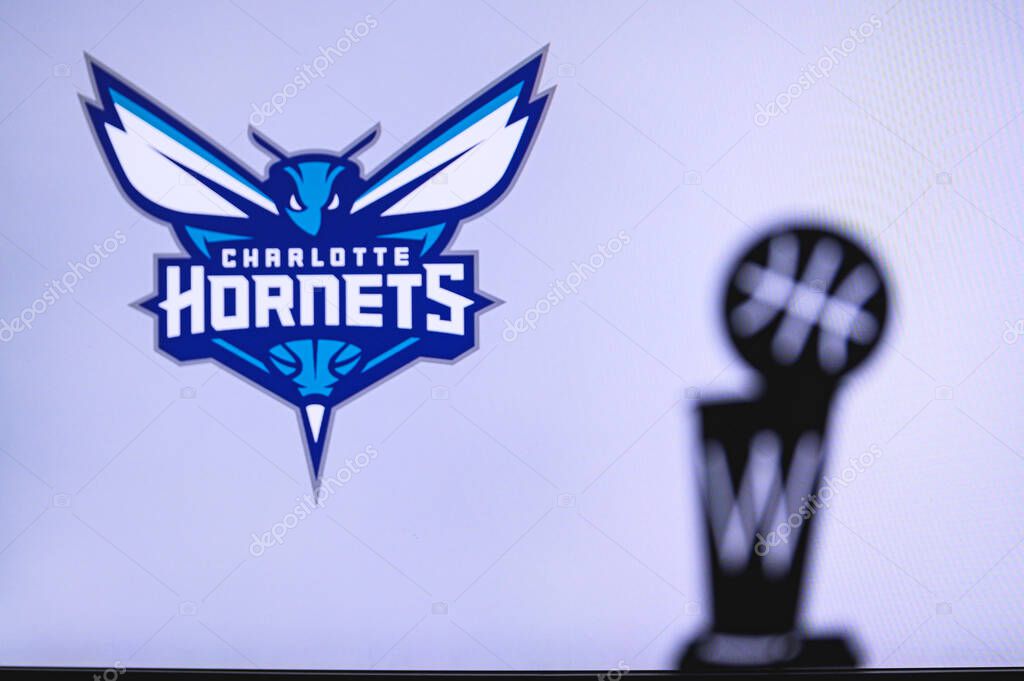 NEW YORK, USA, JUN 18, 2020: Charlotte Hornets Basketball club on the white screen. Silhouette of NBA trophy in foreground.
