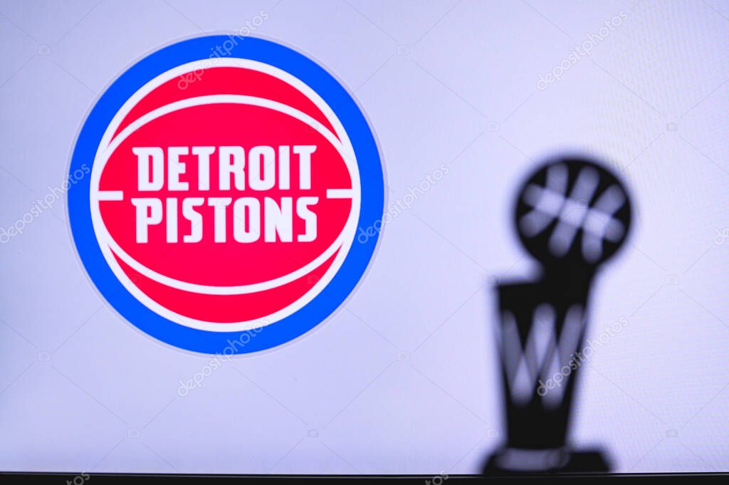 NEW YORK, USA, JUN 18, 2020: Detroit Pistons Basketball club on the white screen. Silhouette of NBA trophy in foreground.