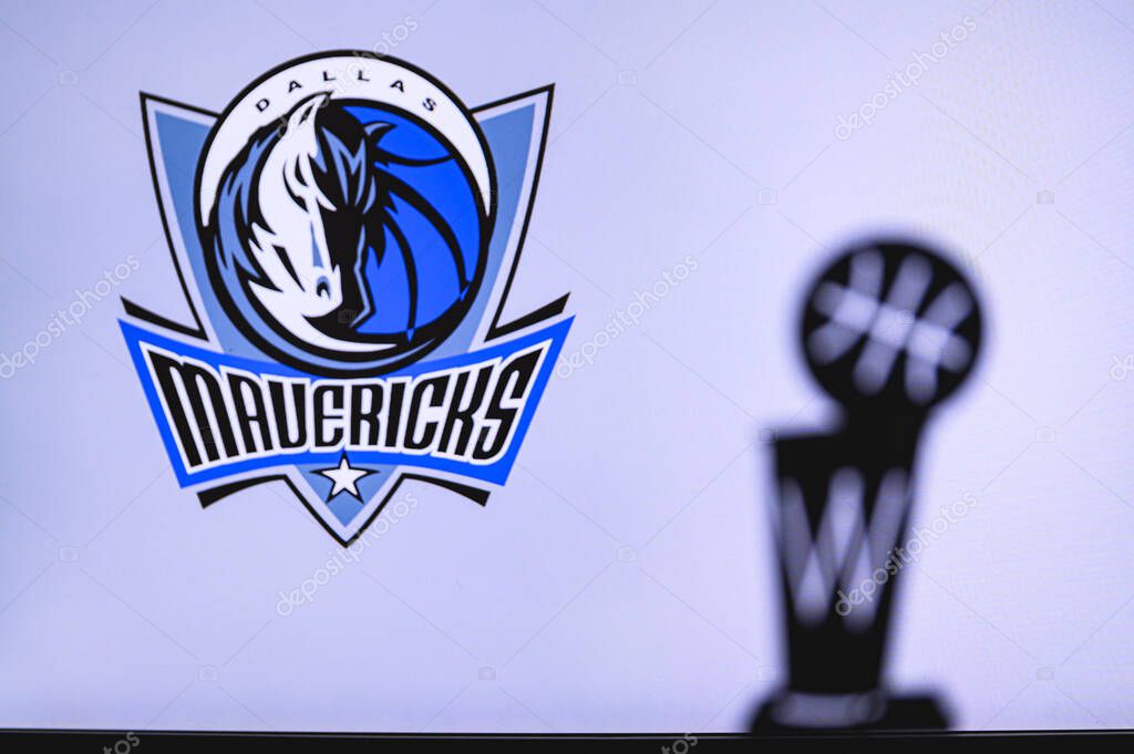 NEW YORK, USA, JUN 18, 2020: Dallas Mavericks Basketball club on the white screen. Silhouette of NBA trophy in foreground.