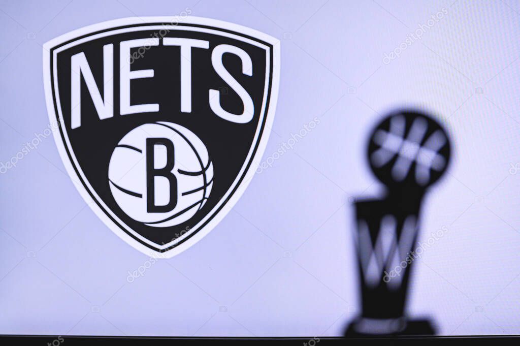 NEW YORK, USA, JUN 18, 2020: Brooklyn Nets Basketball club on the white screen. Silhouette of NBA trophy in foreground.