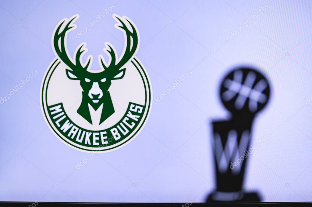 NEW YORK, USA, JUN 18, 2020: Milwaukee Bucks Basketball club on the white screen. Silhouette of NBA trophy in foreground.