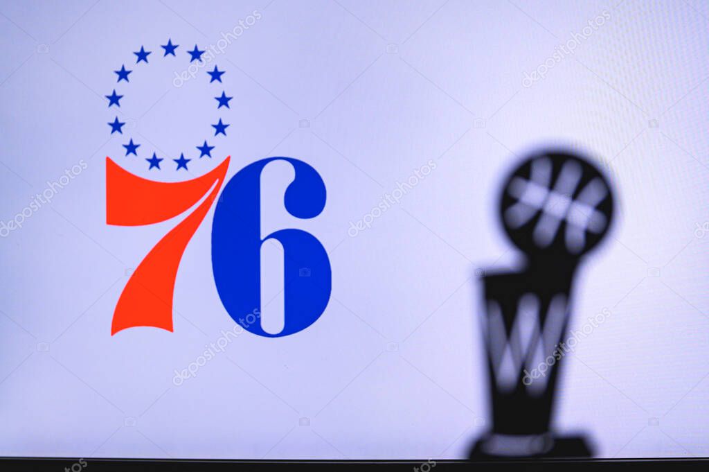 NEW YORK, USA, JUN 18, 2020: Philadelphia 76ers Basketball club on the white screen. Silhouette of NBA trophy in foreground.