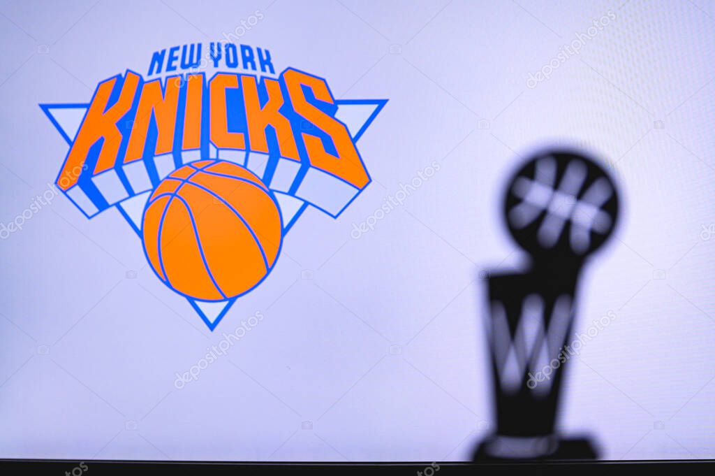 NEW YORK, USA, JUN 18, 2020: New York Knicks Basketball club on the white screen. Silhouette of NBA trophy in foreground.