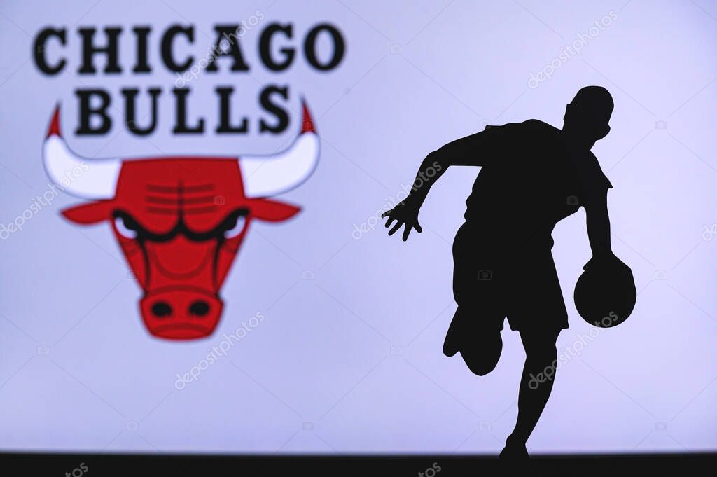NEW YORK, USA, JUN 18, 2020: Chicago Bulls basketball club logo and silhouette of young basketball player. Sport wallpaper, white edit space in background.