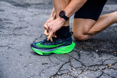 Roma, İtalya, 23 Haziran 'da. 2020: Nike koşu ayakkabıları ALPHAFly 'nin yanında. Tartışmalı yeşil atletizm ayakkabıları yolda koşan profesyonel atletlerin bacaklarında. Tokyo Olimpiyatları için resmi ayakkabı 2020 maratonu