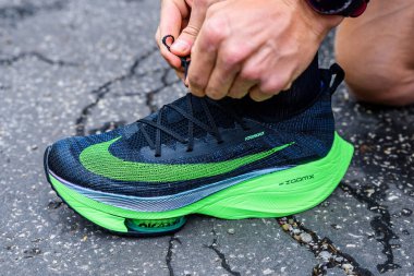 Roma, İtalya, 23 Haziran 'da. 2020: Nike koşu ayakkabıları ALPHAFly 'nin yanında. Tartışmalı yeşil atletizm ayakkabıları yolda koşan profesyonel atletlerin bacaklarında. Tokyo Olimpiyatları için resmi ayakkabı 2020 maratonu