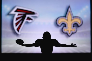 Atlanta Şahinleri, New Orleans Azizleri 'ne karşı. NFL oyunu. Amerikan Futbol Ligi maçı. Profesyonel oyuncunun silueti dokunuşu kutluyor. Arkaplanda ekran.