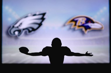 Philadelphia Eagles, Baltimore Ravens 'a karşı. NFL oyunu. Amerikan Futbol Ligi maçı. Profesyonel oyuncunun silueti dokunuşu kutluyor. Arkaplanda ekran.