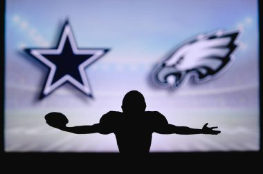 Dallas Cowboys, Philadelphia Eagles 'a karşı. NFL oyunu. Amerikan Futbol Ligi maçı. Profesyonel oyuncunun silueti dokunuşu kutluyor. Arkaplanda ekran.