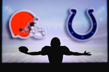 Cleveland Browns Indianapolis Colts 'a karşı. NFL oyunu. Amerikan Futbol Ligi maçı. Profesyonel oyuncunun silueti dokunuşu kutluyor. Arkaplanda ekran.