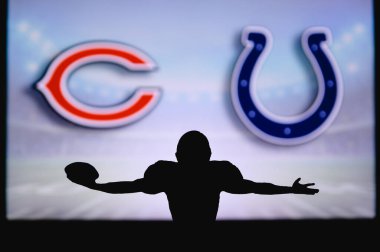 Chicago Bears Indianapolis Colts 'a karşı. NFL oyunu. Amerikan Futbol Ligi maçı. Profesyonel oyuncunun silueti dokunuşu kutluyor. Arkaplanda ekran.
