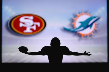 San Francisco 49ers Miami Dolphins 'e karşı. NFL oyunu. Amerikan Futbol Ligi maçı. Profesyonel oyuncunun silueti dokunuşu kutluyor. Arkaplanda ekran.