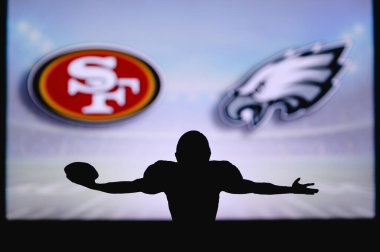 San Francisco 49ers, Philadelphia Eagles 'a karşı. NFL oyunu. Amerikan Futbol Ligi maçı. Profesyonel oyuncunun silueti dokunuşu kutluyor. Arkaplanda ekran.