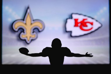 New Orleans Saints, Kansas City Chiefs 'e karşı. NFL oyunu. Amerikan Futbol Ligi maçı. Profesyonel oyuncunun silueti dokunuşu kutluyor. Arkaplanda ekran.