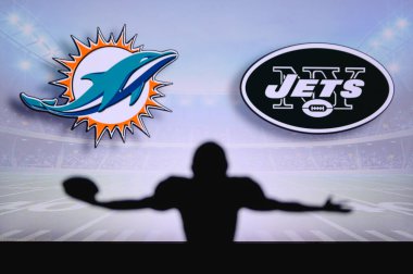 Miami Dolphins, New York Jets 'e karşı. NFL oyunu. Amerikan Futbol Ligi maçı. Profesyonel oyuncunun silueti dokunuşu kutluyor. Arkaplanda ekran.